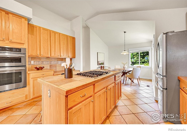 2226 Eagles Nest Dr, Lafayette, CO 80026 - kitchen featuring stainless steel appliances, tile countertops, lofted ceiling, backsplash, and light tile patterned floors