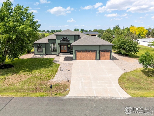 5217 Dry Creek Rd, Evans, CO 80634 - view of front of property with a garage, concrete driveway, french doors, stucco siding, and roof with shingles