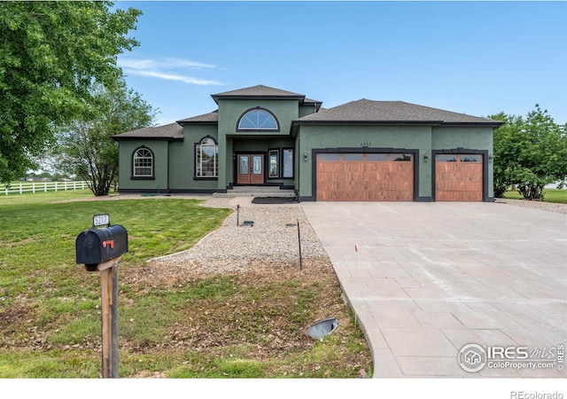 5217 Dry Creek Rd, Evans, CO 80634 - view of front of house featuring an attached garage, concrete driveway, french doors, and stucco siding