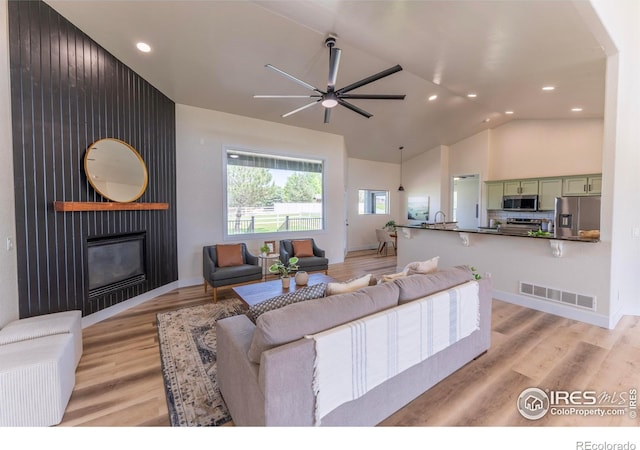 5217 Dry Creek Rd, Evans, CO 80634 - living area with ceiling fan, a fireplace, high vaulted ceiling, recessed lighting, and light wood-style floors