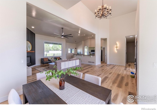 5217 Dry Creek Rd, Evans, CO 80634 - dining room featuring light wood-style flooring, a chandelier, a large fireplace, ceiling fan, and recessed lighting