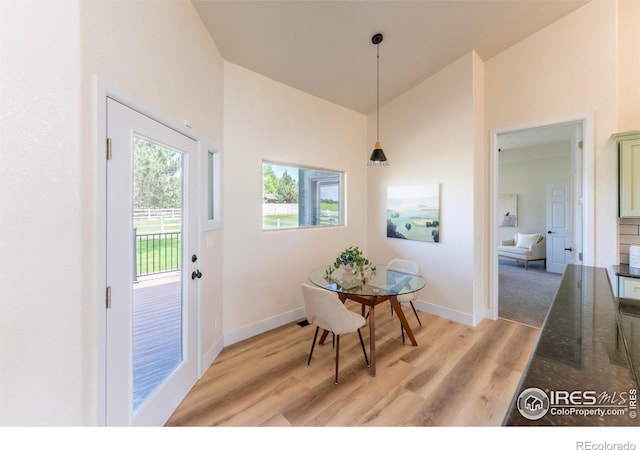 5217 Dry Creek Rd, Evans, CO 80634 - dining room with light wood-style flooring and high vaulted ceiling