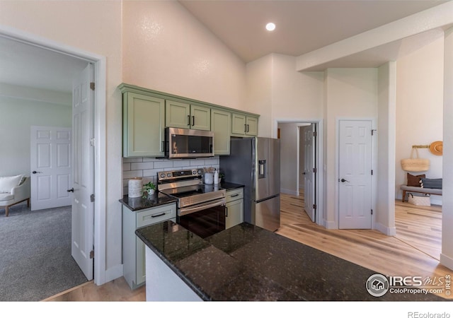 5217 Dry Creek Rd, Evans, CO 80634 - kitchen featuring stainless steel appliances, green cabinetry, a high ceiling, tasteful backsplash, and light wood-type flooring