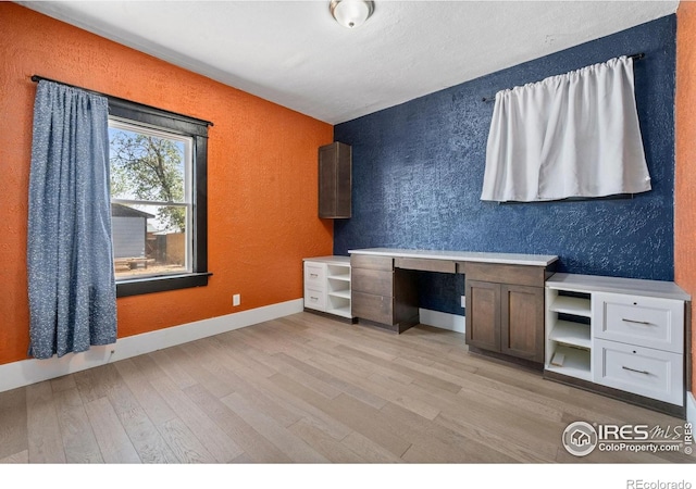 556 Lincoln Ave, Nunn, CO 80648 - unfurnished office with built in desk, a textured wall, and light wood finished floors