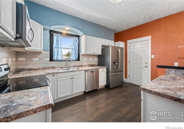 556 Lincoln Ave, Nunn, CO 80648 - kitchen with stainless steel appliances, a textured wall, dark wood finished floors, decorative backsplash, and a textured ceiling