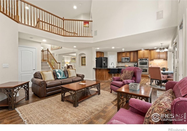 8383 Castaway Dr, Windsor, CO 80528 - living area featuring a towering ceiling, stairs, dark wood-style floors, and recessed lighting