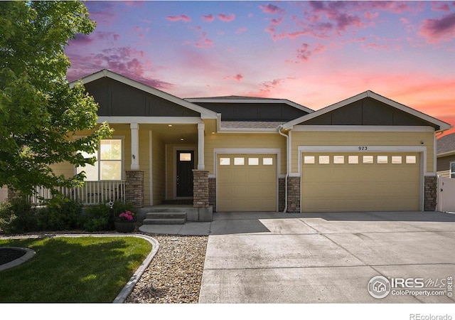 973 Mt Andrew Dr, Severance, CO 80550 - craftsman-style house with an attached garage, stone siding, driveway, and covered porch