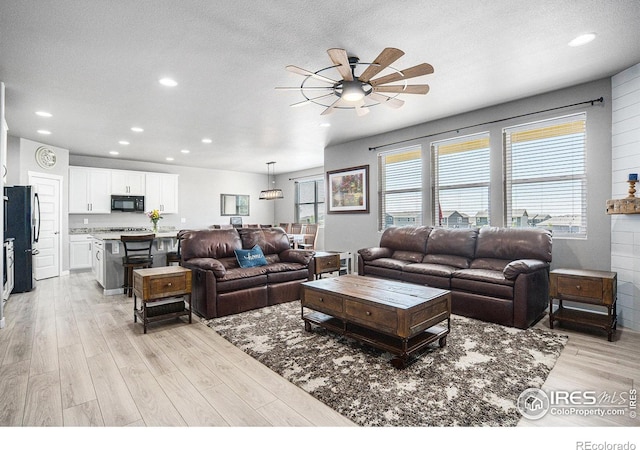 973 Mt Andrew Dr, Severance, CO 80550 - living area featuring ceiling fan, light wood finished floors, recessed lighting, and a textured ceiling