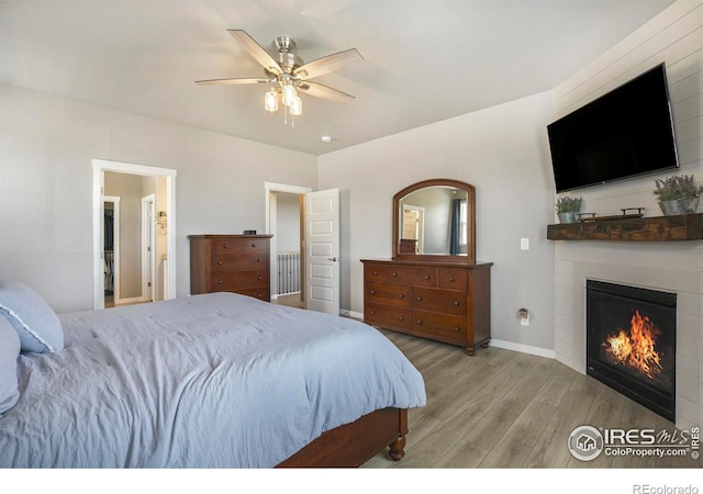 973 Mt Andrew Dr, Severance, CO 80550 - bedroom with wood finished floors, a large fireplace, and a ceiling fan