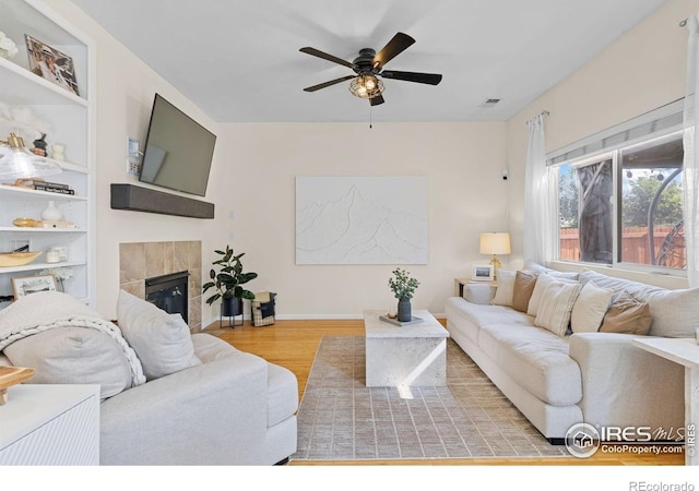 3826 Glenarbor Ln Unit F, Fort Collins, CO 80524 - living area with wood finished floors, ceiling fan, and a fireplace