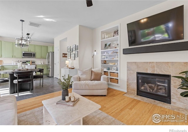 3826 Glenarbor Ln Unit F, Fort Collins, CO 80524 - living room featuring built in shelves, light wood-type flooring, and a tile fireplace