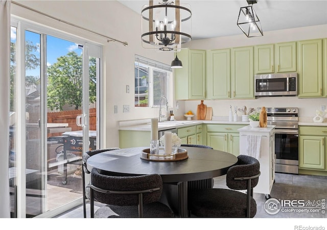 3826 Glenarbor Ln Unit F, Fort Collins, CO 80524 - kitchen featuring stainless steel appliances, green cabinets, light countertops, and a chandelier