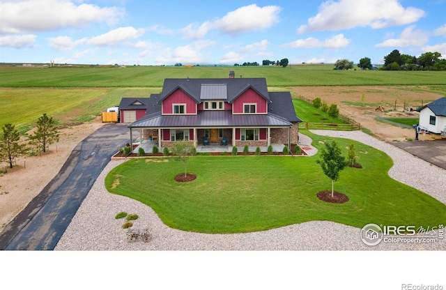 9260 Meadow Farms Dr, Milliken, CO 80543 - view of front of house featuring covered porch, a rural view, a front yard, and asphalt driveway