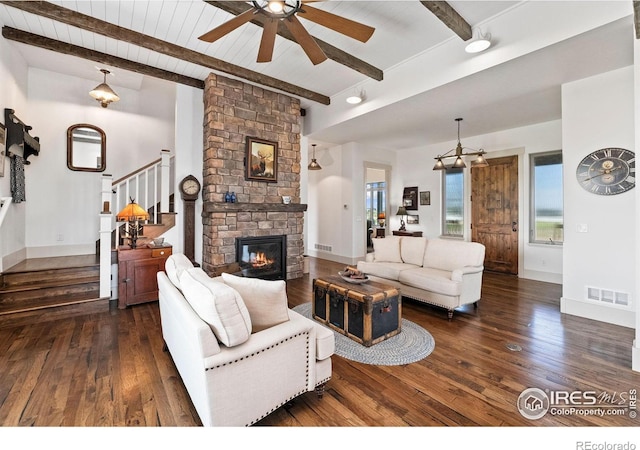 9260 Meadow Farms Dr, Milliken, CO 80543 - living area with dark wood-type flooring, a ceiling fan, stairs, a fireplace, and a wooden ceiling with exposed beams