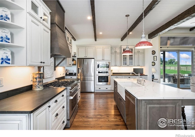 9260 Meadow Farms Dr, Milliken, CO 80543 - kitchen with appliances with stainless steel finishes, beamed ceiling, dark wood-style floors, open shelves, and an island with sink
