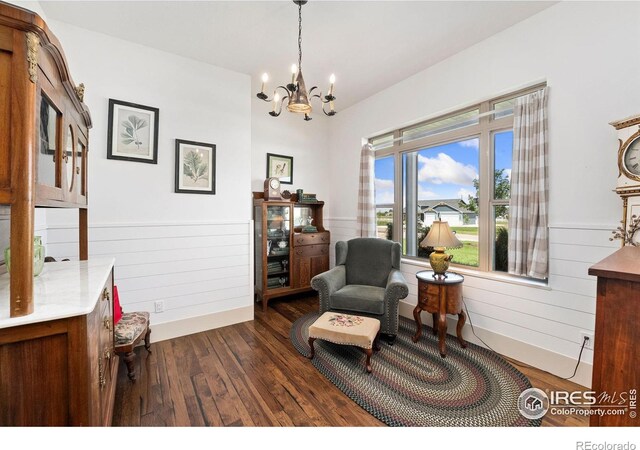 9260 Meadow Farms Dr, Milliken, CO 80543 - sitting room with a wainscoted wall, dark wood-style flooring, a chandelier, and wooden walls