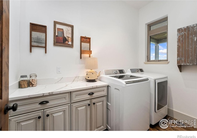 9260 Meadow Farms Dr, Milliken, CO 80543 - washroom featuring washer and dryer, cabinet space, and wood finished floors