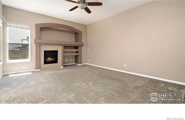 3664 Claycomb Ln, Johnstown, CO 80534 - unfurnished living room featuring a ceiling fan, carpet, and a tiled fireplace