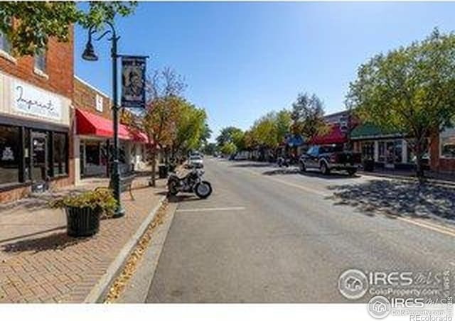 3664 Claycomb Ln, Johnstown, CO 80534 - view of asphalt road featuring sidewalks, street lights, and curbs