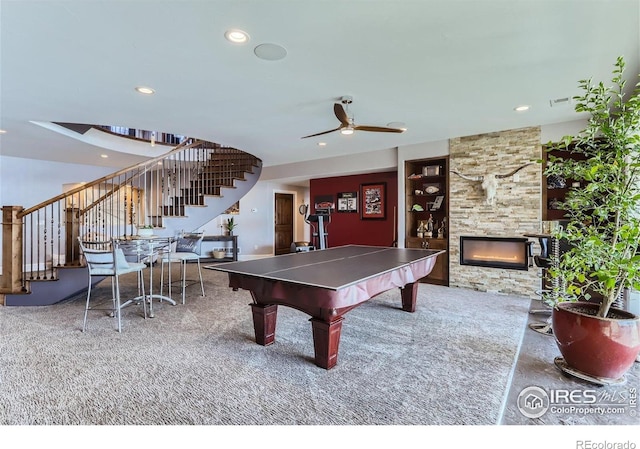 5763 Pelican Shores Dr, Longmont, CO 80504 - rec room with carpet floors, a stone fireplace, a ceiling fan, built in features, and recessed lighting