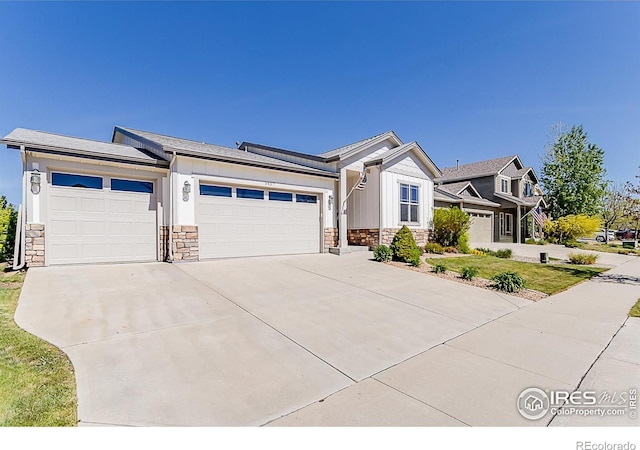 5457 Wishing Well Dr, Timnath, CO 80547 - view of front of house featuring stone siding, an attached garage, concrete driveway, and board and batten siding