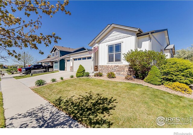 5457 Wishing Well Dr, Timnath, CO 80547 - view of front of property featuring board and batten siding, stone siding, an attached garage, a front yard, and driveway