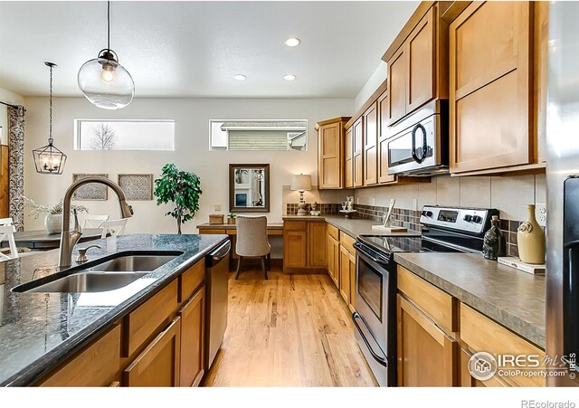 5457 Wishing Well Dr, Timnath, CO 80547 - kitchen featuring stainless steel appliances, light wood finished floors, recessed lighting, hanging light fixtures, and brown cabinetry