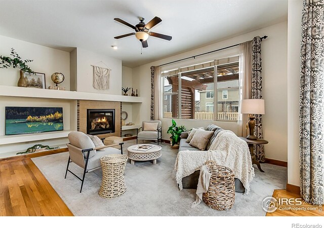 5457 Wishing Well Dr, Timnath, CO 80547 - living area with ceiling fan, wood finished floors, and a glass covered fireplace