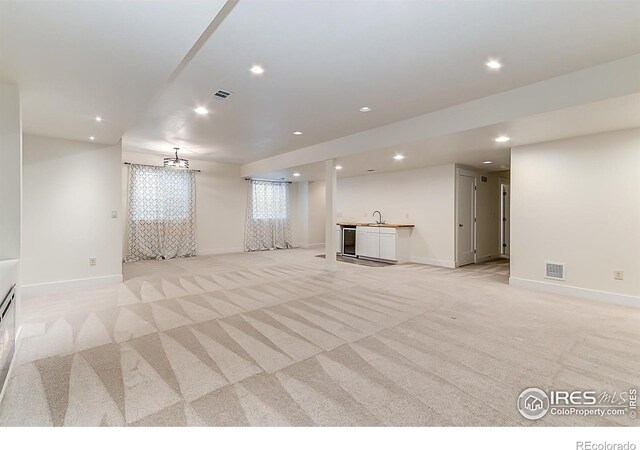 5457 Wishing Well Dr, Timnath, CO 80547 - unfurnished living room with light carpet, bar with sink, and recessed lighting