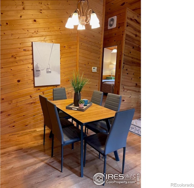33 N Skinner Rd, Allenspark, CO 80510 - dining area featuring a chandelier, wood walls, and light wood-type flooring