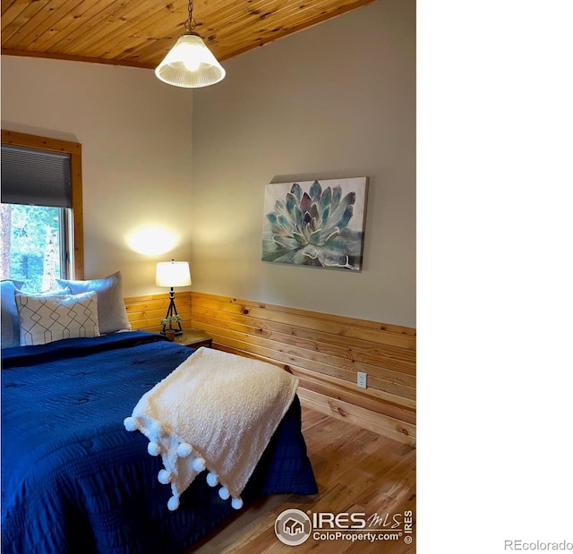 33 N Skinner Rd, Allenspark, CO 80510 - bedroom with wood ceiling, wood finished floors, wooden walls, and a wainscoted wall