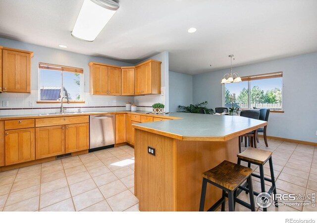 1204 Boulder Ct, Windsor, CO 80550 - kitchen with dishwasher, a breakfast bar, backsplash, light tile patterned flooring, and a chandelier