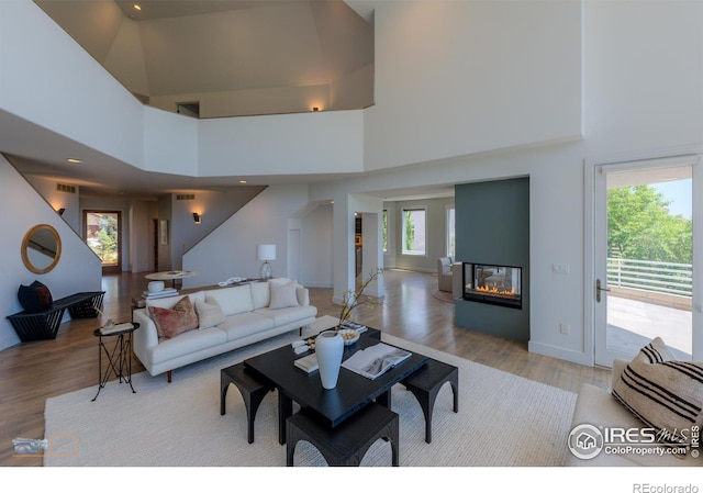 3747 Mountain Laurel Pl, Boulder, CO 80304 - living area with light wood-style flooring, a high ceiling, and a multi sided fireplace