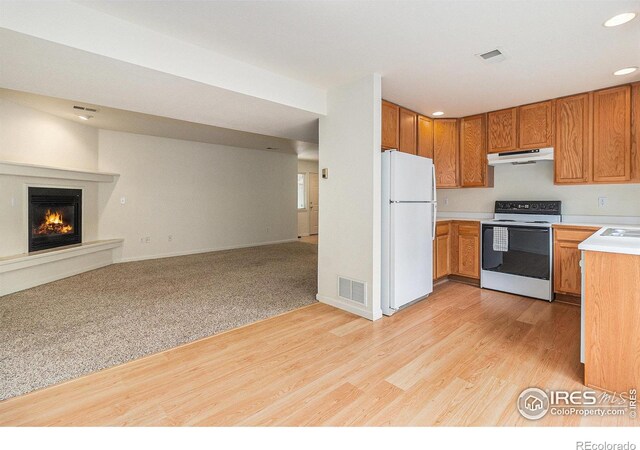 911 Tulip St Unit C, Longmont, CO 80501 - kitchen with white appliances, under cabinet range hood, open floor plan, light countertops, and recessed lighting