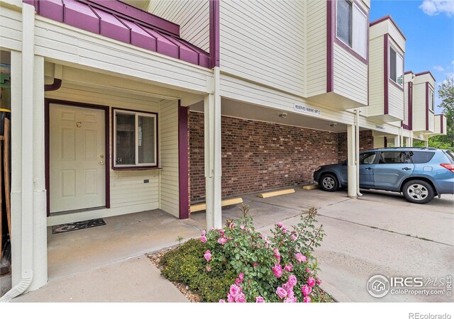 911 Tulip St Unit C, Longmont, CO 80501 - view of exterior entry with brick siding and uncovered parking
