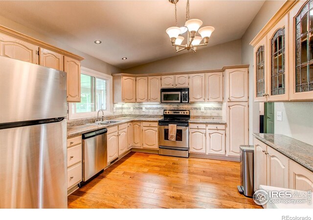 1331 Iva Ct, Fort Collins, CO 80525 - kitchen featuring stainless steel appliances, a chandelier, light brown cabinetry, lofted ceiling, and tasteful backsplash