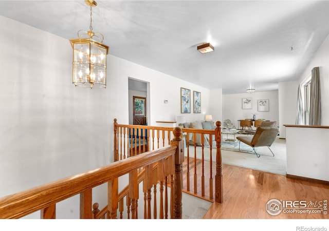 11198 W 59th Pl, Arvada, CO 80004 - corridor with an upstairs landing, wood finished floors, and a chandelier