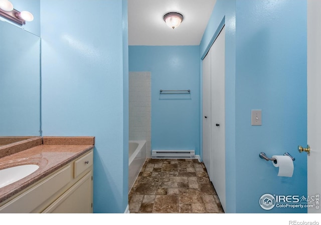 3465 Lochwood Dr Unit 91, Fort Collins, CO 80525 - bathroom featuring stone finish floors, a baseboard radiator, and vanity