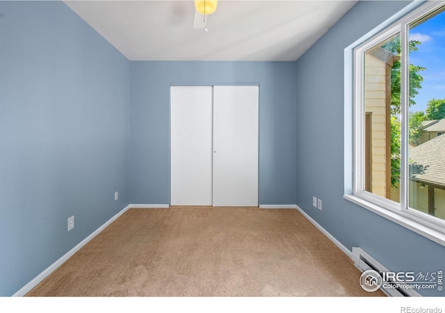 3465 Lochwood Dr Unit 91, Fort Collins, CO 80525 - unfurnished bedroom featuring carpet flooring, a closet, a baseboard radiator, and a ceiling fan