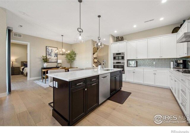 1768 Barefoot Dr, Windsor, CO 80550 - kitchen featuring appliances with stainless steel finishes, white cabinets, light wood-type flooring, decorative backsplash, and recessed lighting