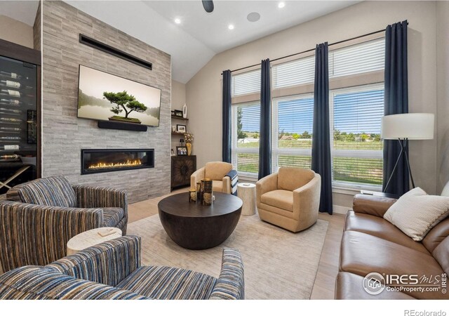 1768 Barefoot Dr, Windsor, CO 80550 - living room featuring wood finished floors, vaulted ceiling, a tiled fireplace, and recessed lighting