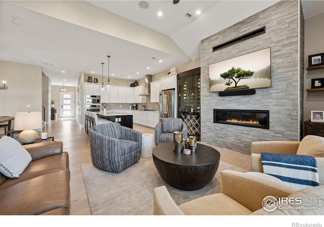 1768 Barefoot Dr, Windsor, CO 80550 - living room featuring light wood-style flooring, a fireplace, recessed lighting, and lofted ceiling