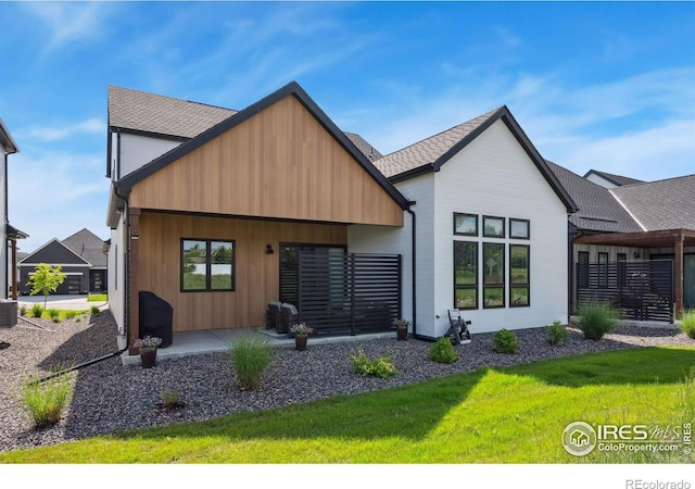 1768 Barefoot Dr, Windsor, CO 80550 - rear view of house featuring a lawn and a shingled roof