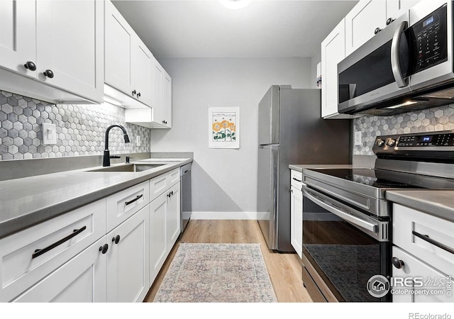 1900 Chalcis Dr Unit 42, Lafayette, CO 80026 - kitchen featuring appliances with stainless steel finishes, tasteful backsplash, white cabinets, and light wood-style floors