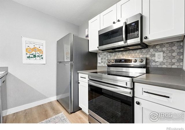 1900 Chalcis Dr Unit 42, Lafayette, CO 80026 - kitchen featuring stainless steel appliances, light wood finished floors, tasteful backsplash, and white cabinetry