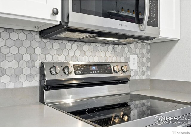 1900 Chalcis Dr Unit 42, Lafayette, CO 80026 - kitchen view of appliances with stainless steel finishes, decorative backsplash, white cabinets, and light countertops