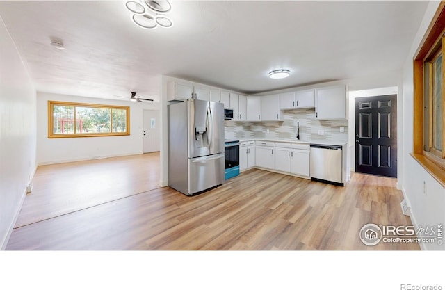 235 N 12th Ave, Brighton, CO 80601 - kitchen with appliances with stainless steel finishes, light countertops, backsplash, light wood-type flooring, and white cabinetry