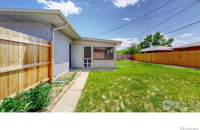 235 N 12th Ave, Brighton, CO 80601 - fenced backyard featuring a sunroom
