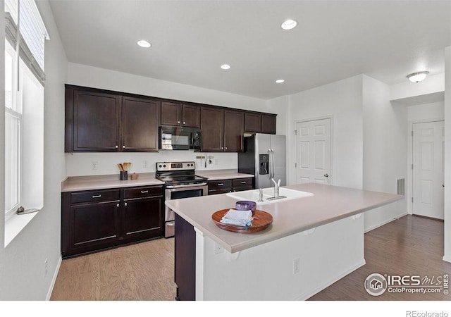 6792 Covenant Ct, Timnath, CO 80547 - kitchen featuring appliances with stainless steel finishes, light wood-style floors, light countertops, dark brown cabinets, and recessed lighting
