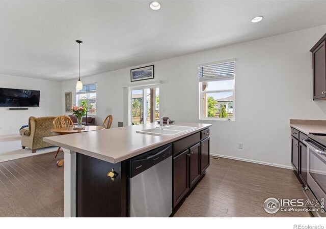 6792 Covenant Ct, Timnath, CO 80547 - kitchen with appliances with stainless steel finishes, dark wood-type flooring, light countertops, open floor plan, and a kitchen island with sink